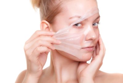 Portrait of girl young woman in facial peel off mask isolated on white. Peeling. Beauty and body skin care. Studio shot.